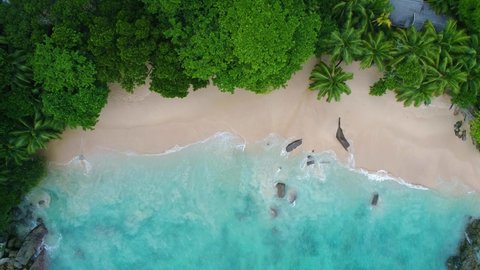 Video from a drone in the Seychelles on a beach called "Sunset Beach" drone camera pointing down