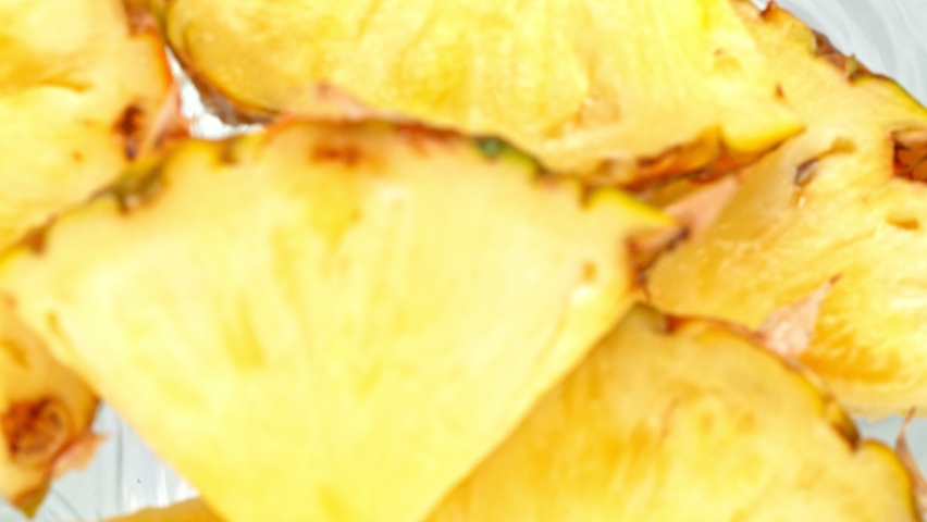 Super Slow Motion Shot of Pineapple Slices Falling Into Water Whirl at 1000 fps.