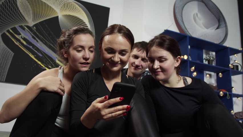 Glad women and men talking via video call during yoga class