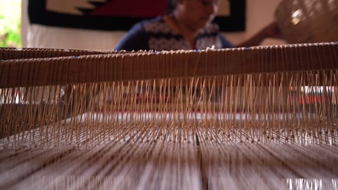 unrecognizable latin woman working on wooden loom