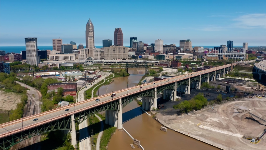Aerial drone forward dolly shot of Cleveland Ohio skyline with cars driving on Hope Memorial bridge which passes over Cuyahoga river in foreground on a sunny afternoon Royalty-Free Stock Footage #1075861766
