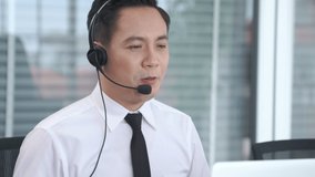 Businessman wearing headset working actively in office . Call center, telemarketing, customer support agent provide service on telephone video conference call.