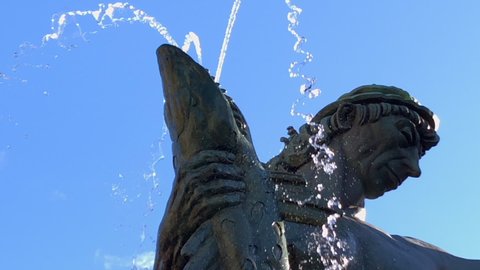 Gothenburg, Sweden - September 28 2018: The statue "Poseidon" in Gothenburg Sweden. Close up footage of the head and fish. Slow motion. Bright blue sky in the background.