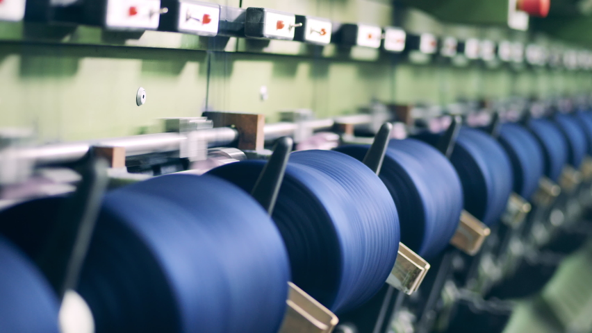 Multiple spools with coloured threads during mechanical sewing. Textile factory production equipment. Royalty-Free Stock Footage #1075869644