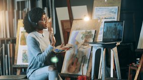 African-american woman is having a remote painting class. Art education concept.