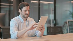 Mature Adult Man making Video Chat on Tablet in Office 