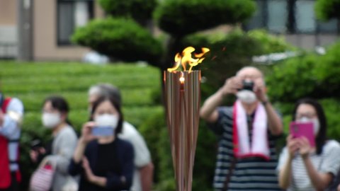 GOTENBA-SHI, SHIZUOKA, JAPAN - 25 JUNE 2021 : Tokyo 2020 Olympic Torch Relay at Gotenba-shi area. Close up shot of torch fire. Slow motion shot.