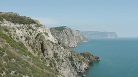 Picturesque coast with rocky cliffs and blue sea. Action. Seascape with rocky coast. Amazing beauty of rocky coast of Black Sea in Crimea
