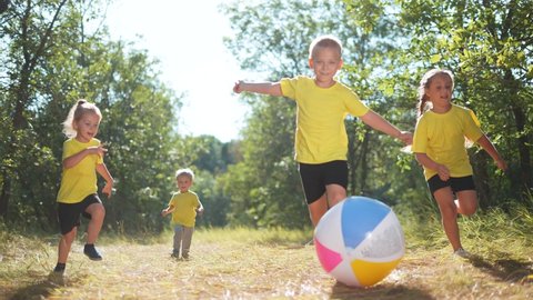 children playing ball in the park. happy family a kid run dream concept. children kick the ball in the park. happy family playing. kid play run sunlight ball in the summer park. dream happy childhood