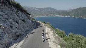 Couple man and woman on the Electric Scooter Aerial seaside scene in LOG 4K Flat Format Ready for Grading - Powered by Shutterstock - Get 15% off with code: PIKWIZARD15