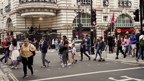 London, UK - 2021.07.11: Euro 2020 football fans walking down the road wearing English flags as a capes