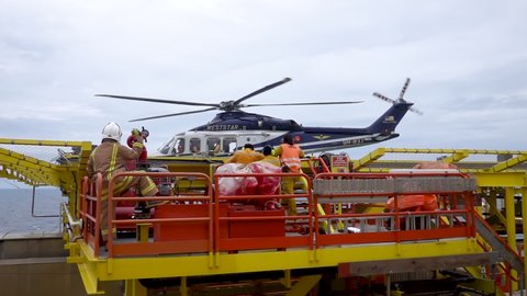 KELANTAN, MALAYSIA - OCT 22nd 2021: Slow motion footage of Weststar AW139 helicopter on air loaded with onshore passengers ready for take off on helicopter deck at oil and gas platform.