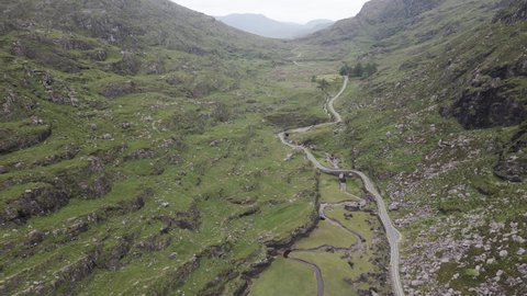 Lush Rocky Mountain Valley With Remote Road At Gap Of Dunloe In Kerry County, Ireland. - Aerial Pullback Shot