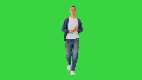 Young white man runs smiling on a Green Screen, Chroma Key.