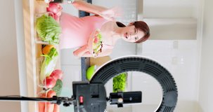 vertical of asian pretty live streamer introduce how to eat healthy online by smart phone with fruits and vegetables