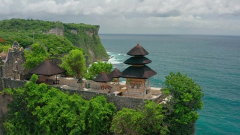 Pura Uluwatu temple. Stone cliffs, ocean waves and oceanscape. Aerial top view. Bali, Indonesia.
