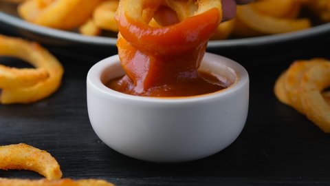 Dipped, Spicy Seasoned Curly Fries in ketchup