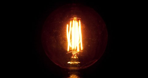 Edison Lamp Flicker At Night. Dirty Light Bulb Glass With Scratches Evokes Horror. Bright Glowing and Flickering Edison Led Lamp with Vintage Form. Halloween and Scary Scenes Concept. Flashing Diodes