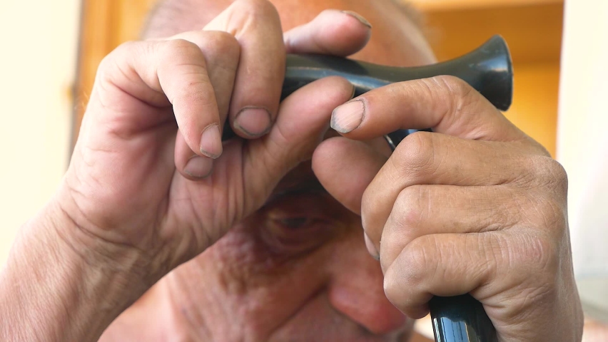portrait of a sad pensioner with a cane. Caucasian elderly man over 70 leaning his head against a cane while sitting in his hands. Elderly man in old age. Selective focus