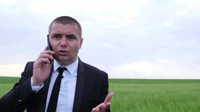 Young businessman in business clothes speaks aggressively on a mobile phone. 