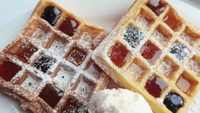 Traditional waffles with honey and vanilla ice cream. Rotate slow motion video. Sweet breakfast. Top view. Warm bakery cuisine. Homemade yummy dessert. Tasty snack