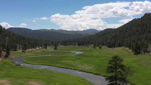 4K UHD video aerial footage flying over the North Fork of the South Platte River in a beautiful green valley in Colorado, USA.