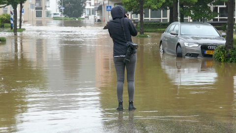 Netherlands - 15 july 2021, Valkenburg: Flooding after heavy rain in the province of South Limburg- woman takes pictures of flooded streets