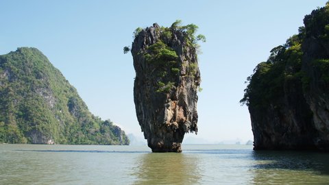 The famous karst, Khao Phing Kan in Phang Nga Bay, Phuket Thailand. This famous karst rock grows out the calm green Andaman sea on a bright sunny day.