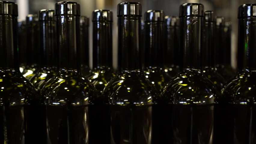 Empty bottles moving along on a conveyor belt to be filled and labeled for sale and distribution - isolated 