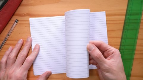 Male Hands Turning Blank Pages Of A Notebook On The Table. overhead