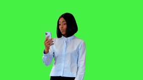 Cute african american girl in 20s talk on video phone call, shy start posing for trendy selfie photo on a Green Screen, Chroma Key.
