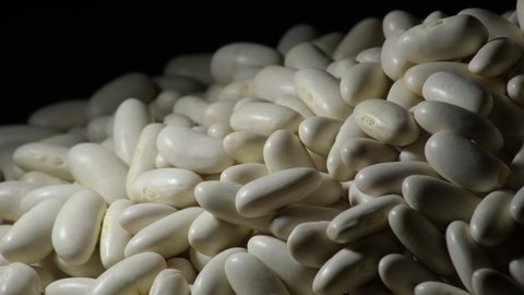 Raw white beans mountain gyrating with black background