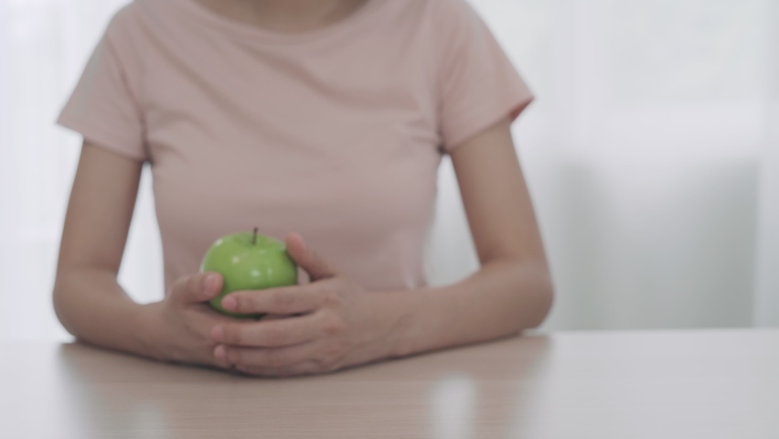 Women refuse to eat cake chocolate and choose to eat green apple. Diet for Healthy women and strong bodies. Cake have many of fat . diet concept. Royalty-Free Stock Footage #1075979588