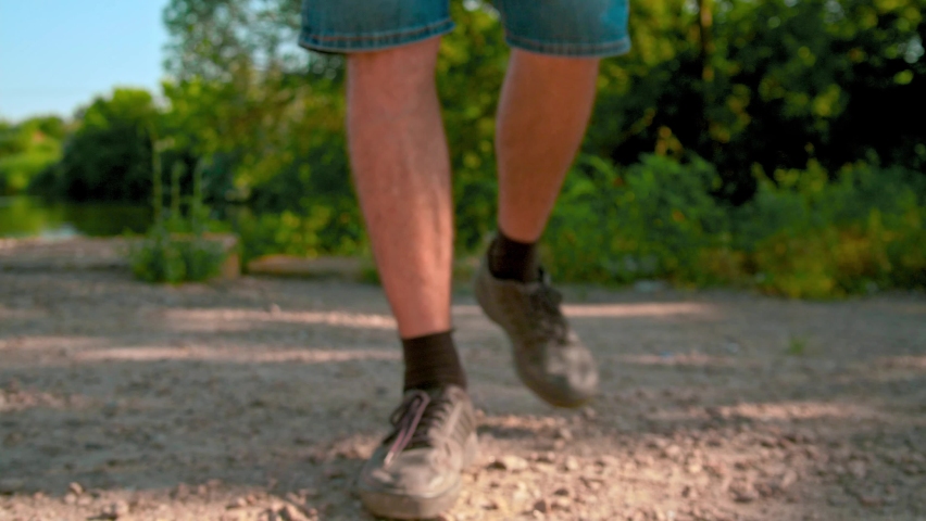 Close-up legs in sneakers go un sun