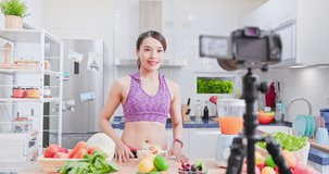 Asian Fitness woman records training on vegetarian cooking - Distances diet through camera video tutorial