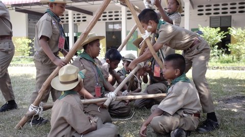 Yala, Thailand March 11, 2016  Thai Boy Scout activities students boys in uniform making wooden catapult learn to build frame attach sticks with a rope Ban Yala primary school