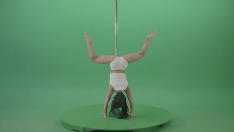 Pole Dance Girl waving two legs standing on hands. Fit pole dancer girl in white underwear performing a rousing contemporary dance moves on pylon on green chromakey background.