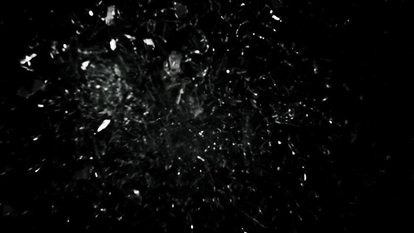 Super Slow Motion studio full-frame wide plate shot of window glass pane shattering and breaking on black background. Real smash explosion at high speed as action concept template and overlay element.