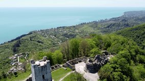 Aerial video from the drone. Bright and luscious mountain landscape on the Black Sea coast in Abkhazia. Scenic view of the Anakopia fortress on top of a mountain in the city of New Athos.