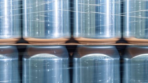 Empty beer cans for cold beverage stored on pallet rack in industrial warehouse, filmed in close up video clip