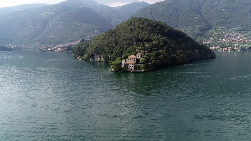 Aerial view arriving at Villa del Balbianello is a mansion in the comune of Lenno province of Como and is famous for its elaborate terraced gardens at this moment a popular visit for tourists 4k Royalty-Free Stock Footage #1076007221