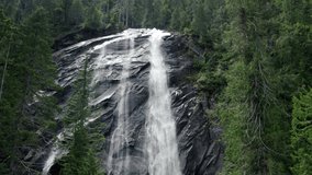 Looking Up at Massive Waterfall Spray Cascading Over Rock Cliff. 4K 60p drone video of Bridal Veil Falls in Washington State