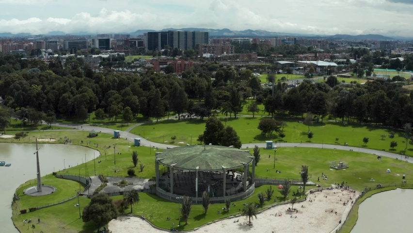 View of lake, chaple and big christian cross in Simón Bolívar Metropolitan Park. Nature, entertainment and sports complex and popular public park in the center of Bogota in Colombia. Drone 4K video.