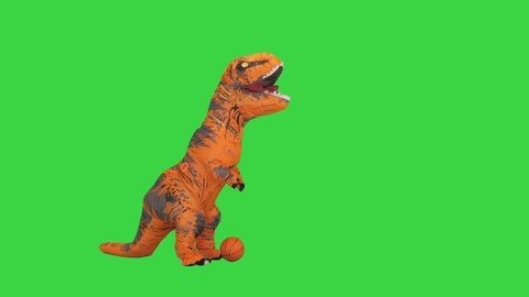 Man in a t-rex costume playing with a ball on a Green Screen, Chroma Key.