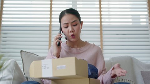 Upset mad asia people young girl consumer sit sofa at home open fake product order, damage post mail buy from online shopping retail store. Shock sad teen woman unbox from wrong bad shipping service.