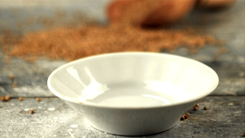Super slow motion fresh mustard falls into a plate on the table. On a gray background. Filmed on a high-speed camera at High quality FullHD footage