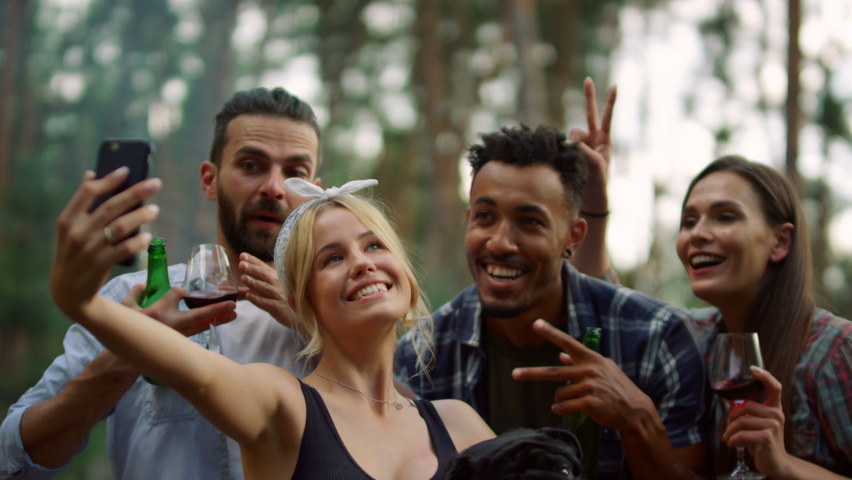 Closeup happy multiracial people posing for self portrait on backyard. Portrait of smiling friends taking selfie photo with dog outdoors. Friendly guys making group photo in summer forest. Royalty-Free Stock Footage #1076026598