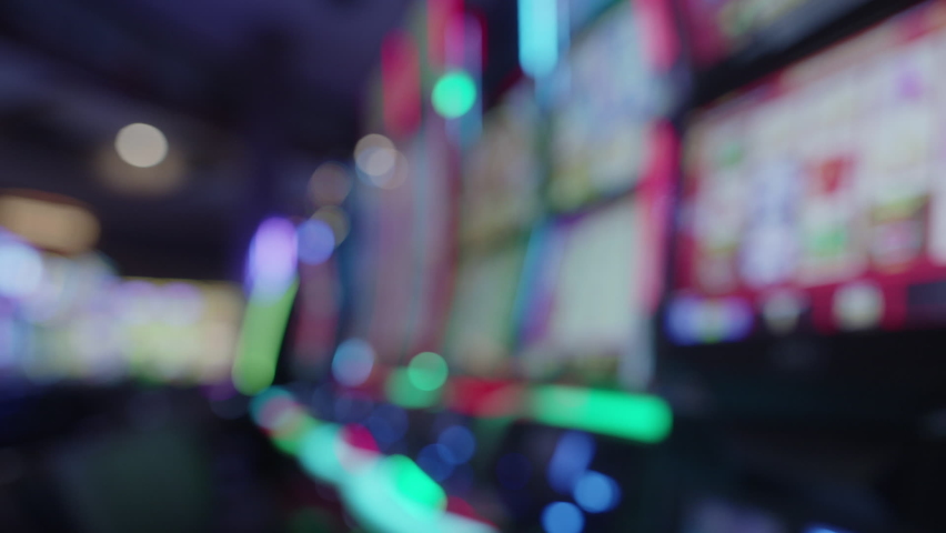 Blurry Shot Of Slot Machines With Glowing Lights On A Casino Floor. static
