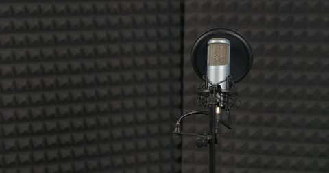 Microphone at stand with pop filter in sound recording studio. 