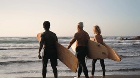 Happy fit surfers with different age and race having fun surfing during sunset time - Extreme sport lifestyle and friendship concept - Powered by Shutterstock - Get 15% off with code: PIKWIZARD15